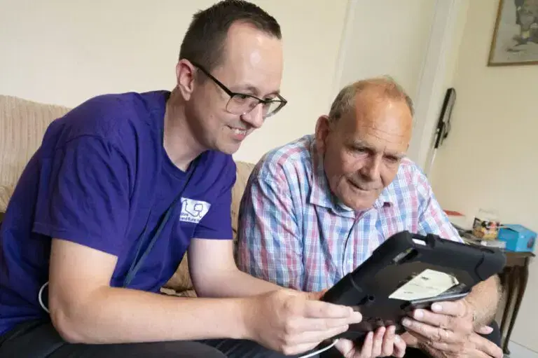 Star employee helping a customer with a tablet inside a home