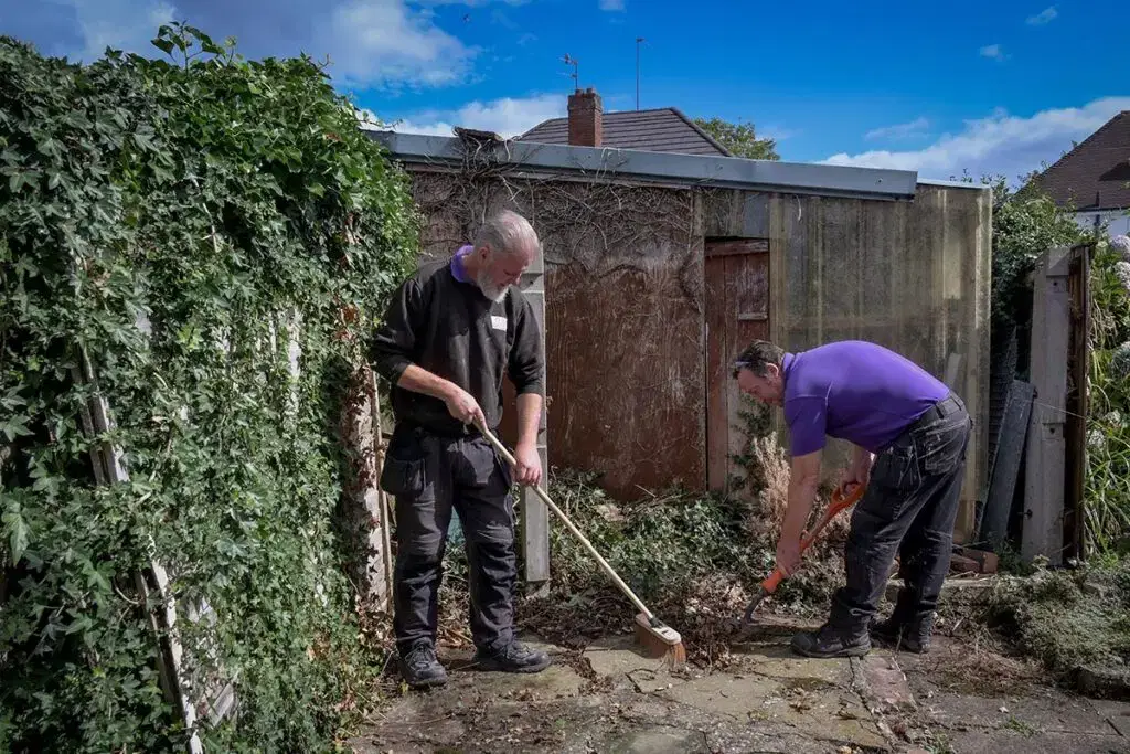 Two star employees working in a garden outside