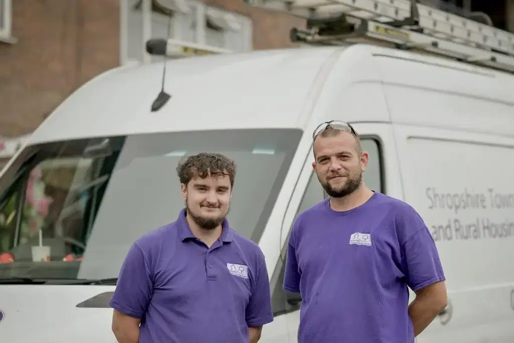 two star employees in front of van