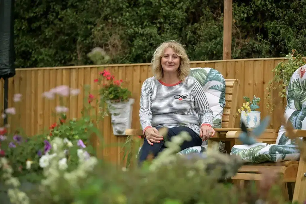 Woman in striped shirt sitting in a garden