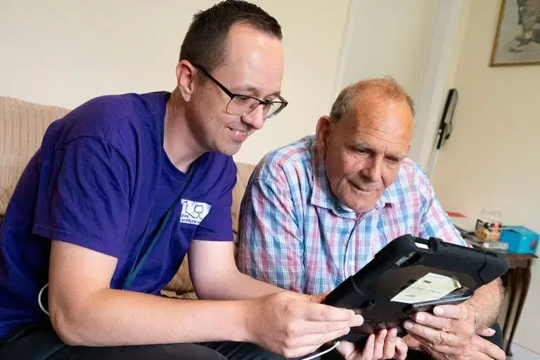 Star employee helping a customer with a tablet inside a home