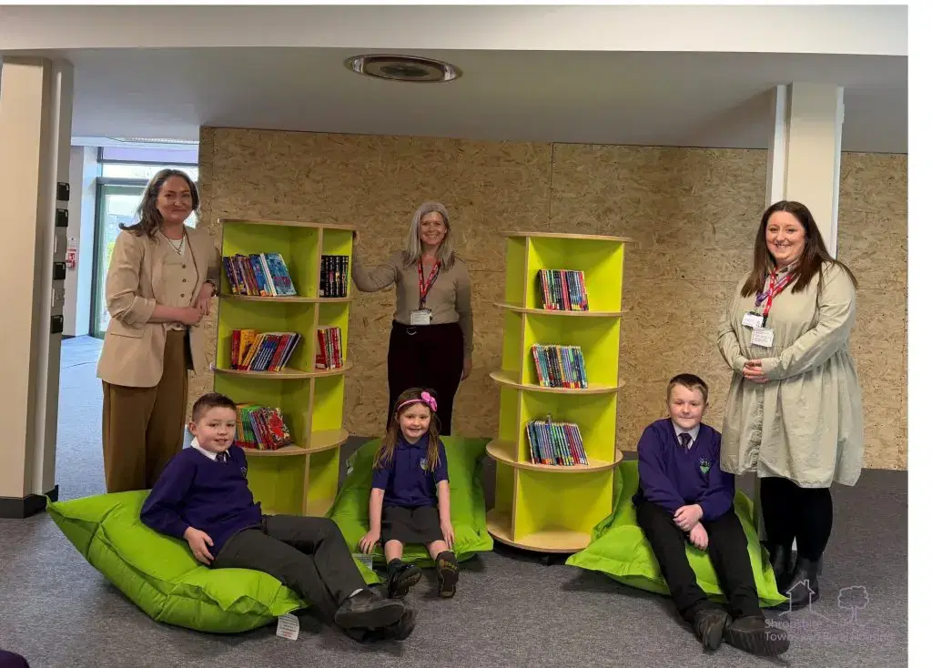 STAR Housing staff with the head teacher and pupils at St Martins School, presenting donations for the library.