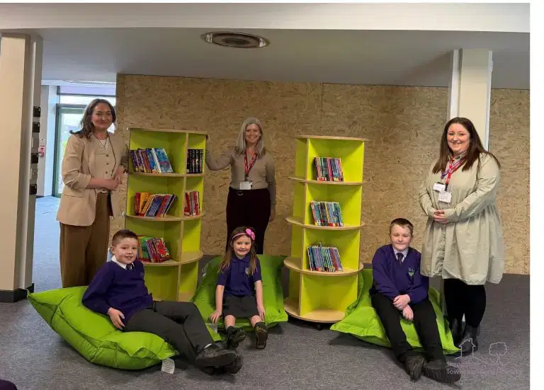 STAR Housing staff with the head teacher and pupils at St Martins School, presenting donations for the library.