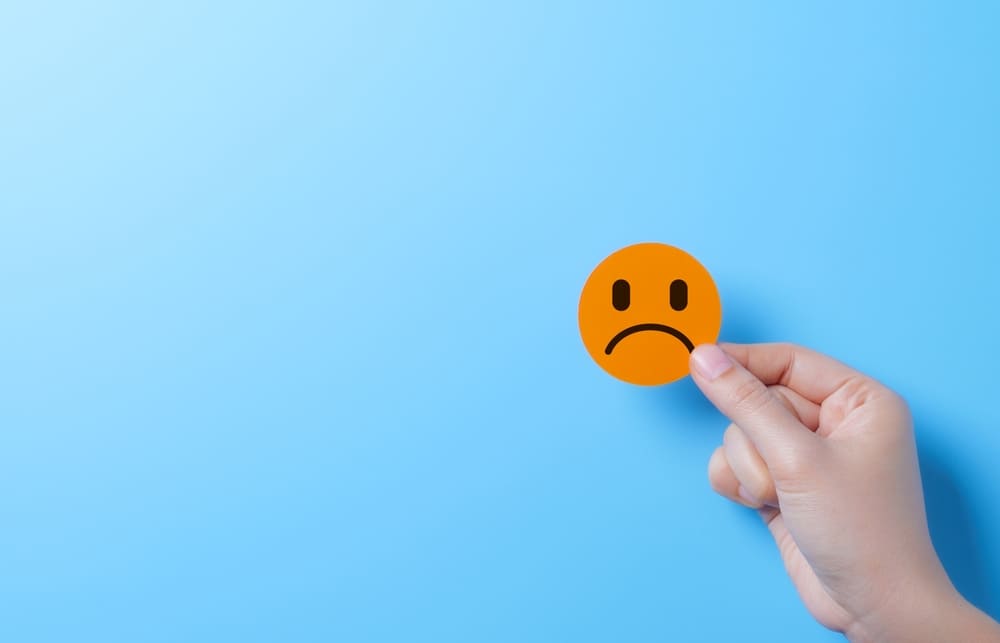 sad smiley face sticker on a blue background