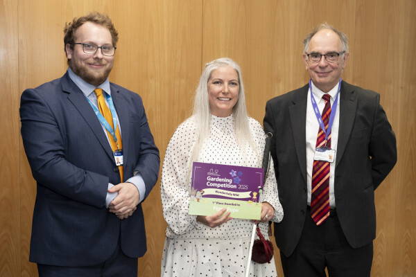two staff with gardening competition winner 