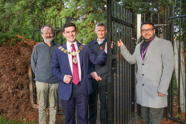 Mayor at a gate with others involved in project