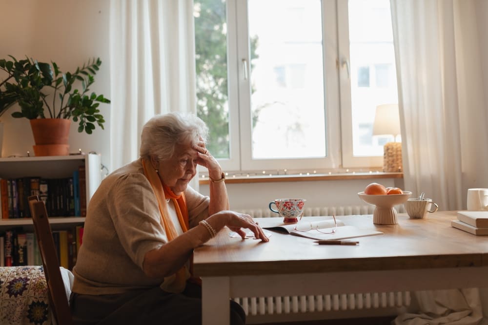 older woman looking worried at a desk