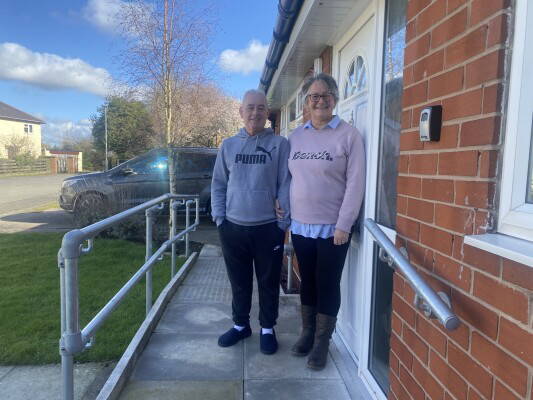 two new home customers in front of new home with ramp