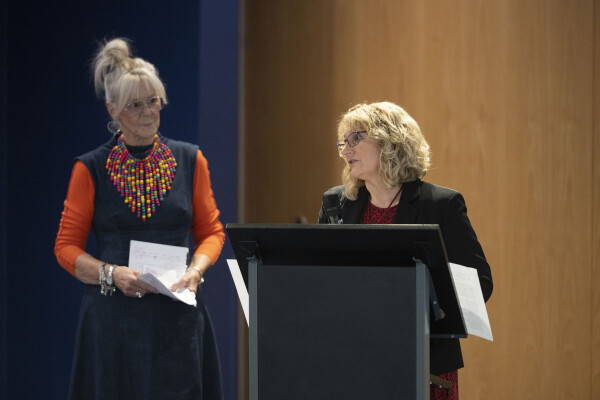 two woman presenting at the front of a conference 