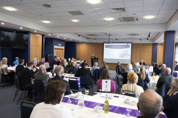 conference room from behind with people looking at a screen at the front 